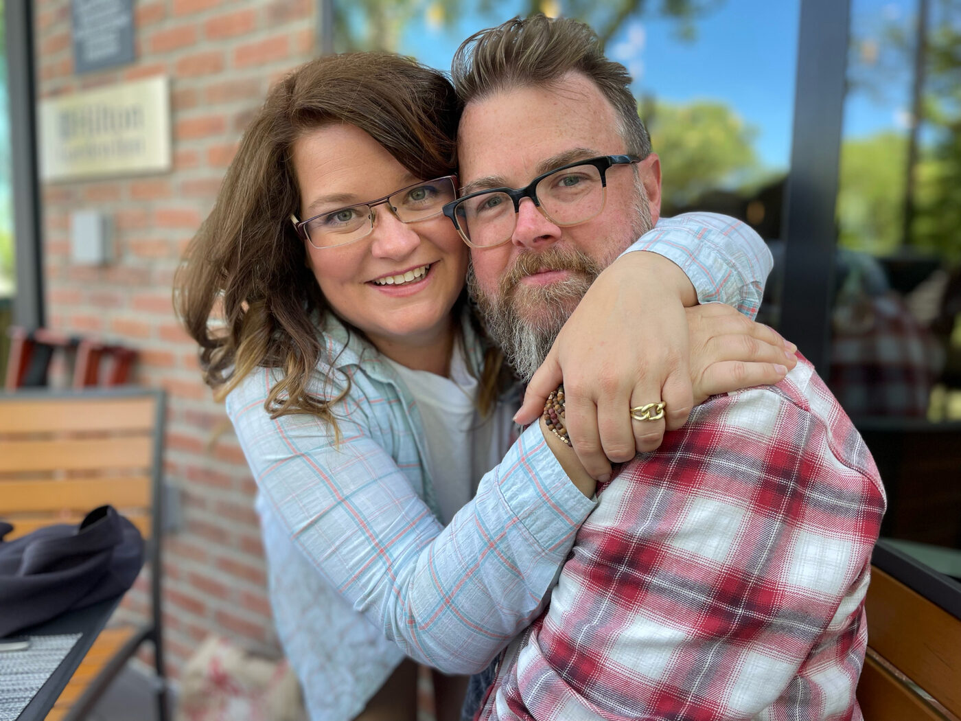 Chris and his wife smiling together at a café